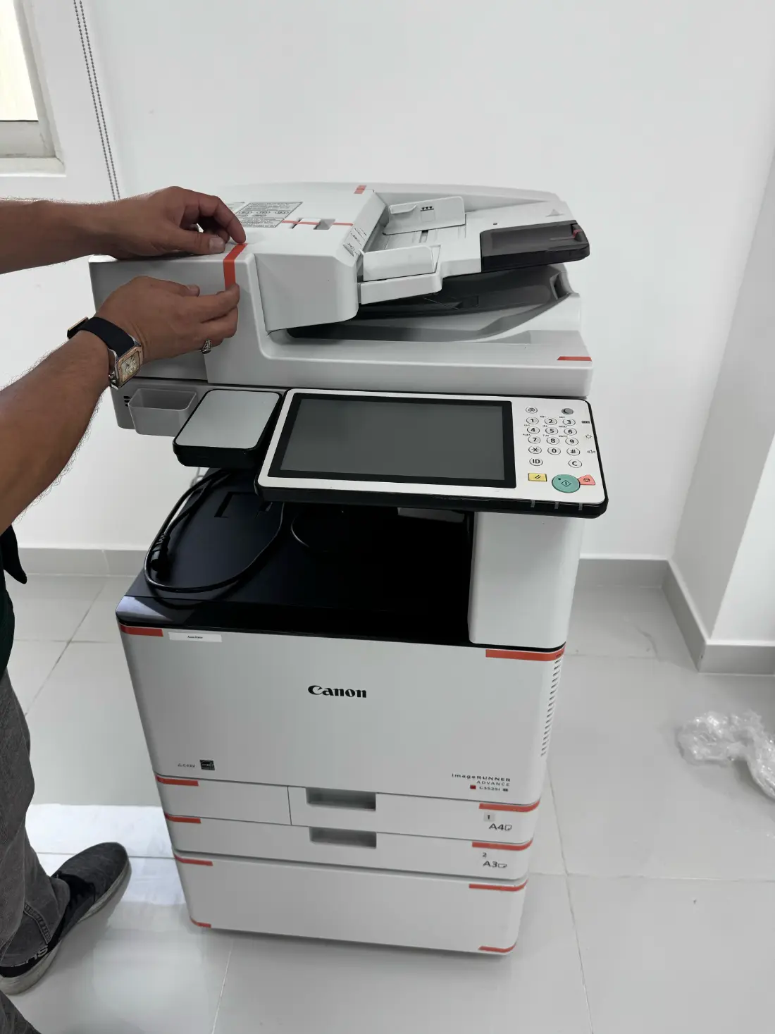 Engineer unpacking a refurbished Canon on site